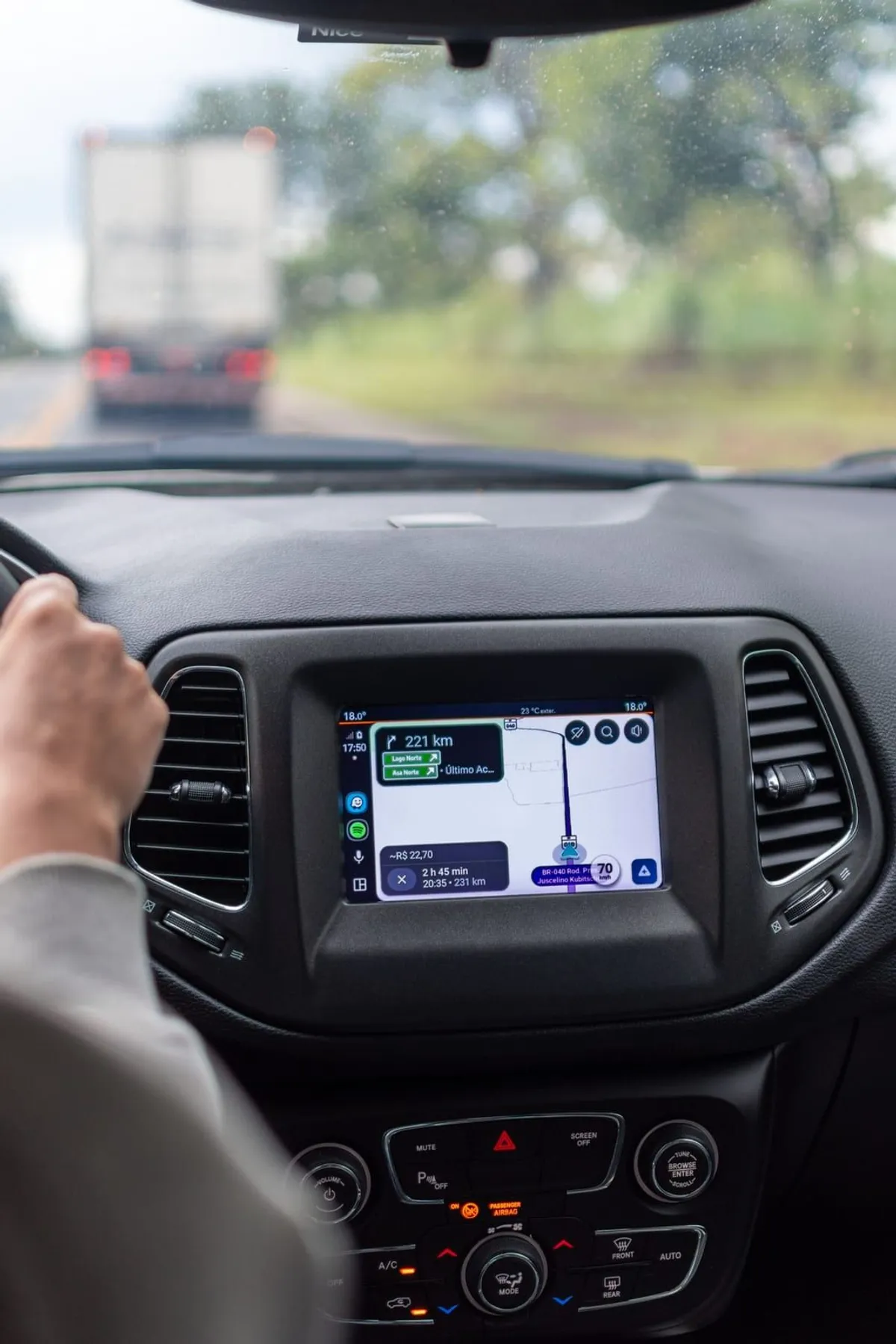 Conductor usando un sistema de navegación GPS dentro de un vehículo en carretera.