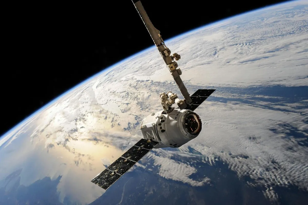 Satélite orbitando la Tierra sobre el océano y formaciones de nubes, vista desde el espacio.