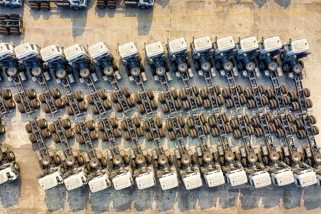 Vista aérea de unidades de autotransporte de carga formadas en un patio logístico.