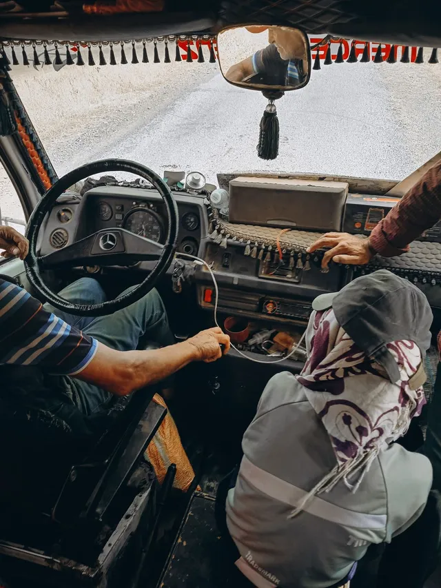 Interior de la cabina de un camión con el tablero y la carretera al frente.