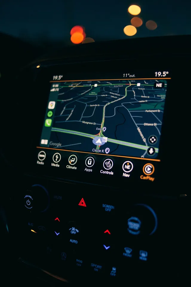 Pantalla de navegación GPS con un mapa mostrando una ruta, dentro de un vehículo.