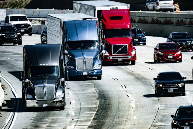Camiones y autos circulando por una carretera, vista de tráfico de transporte.