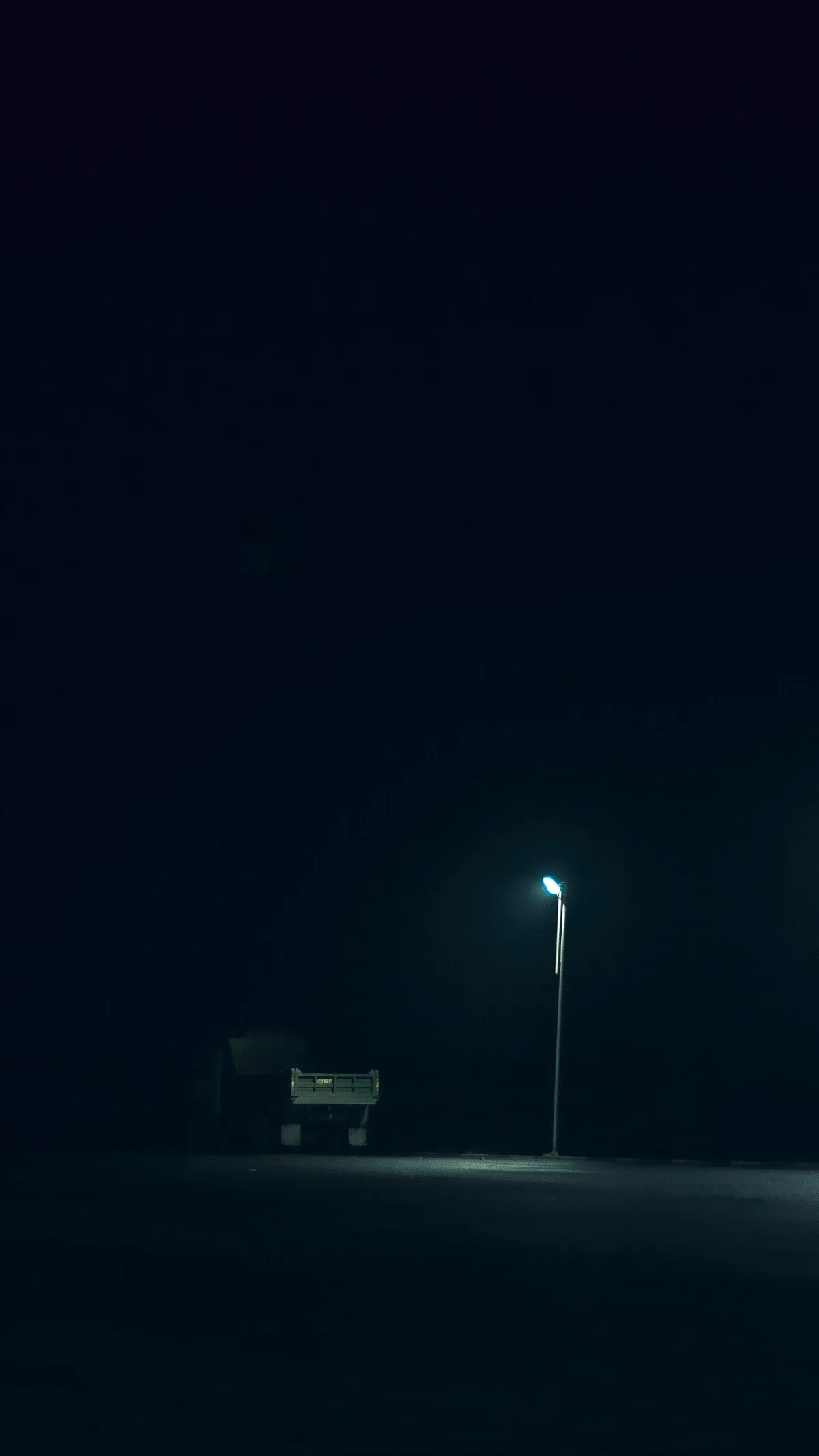 Camión de carga de noche iluminado por la luz de una lámpara de calle.